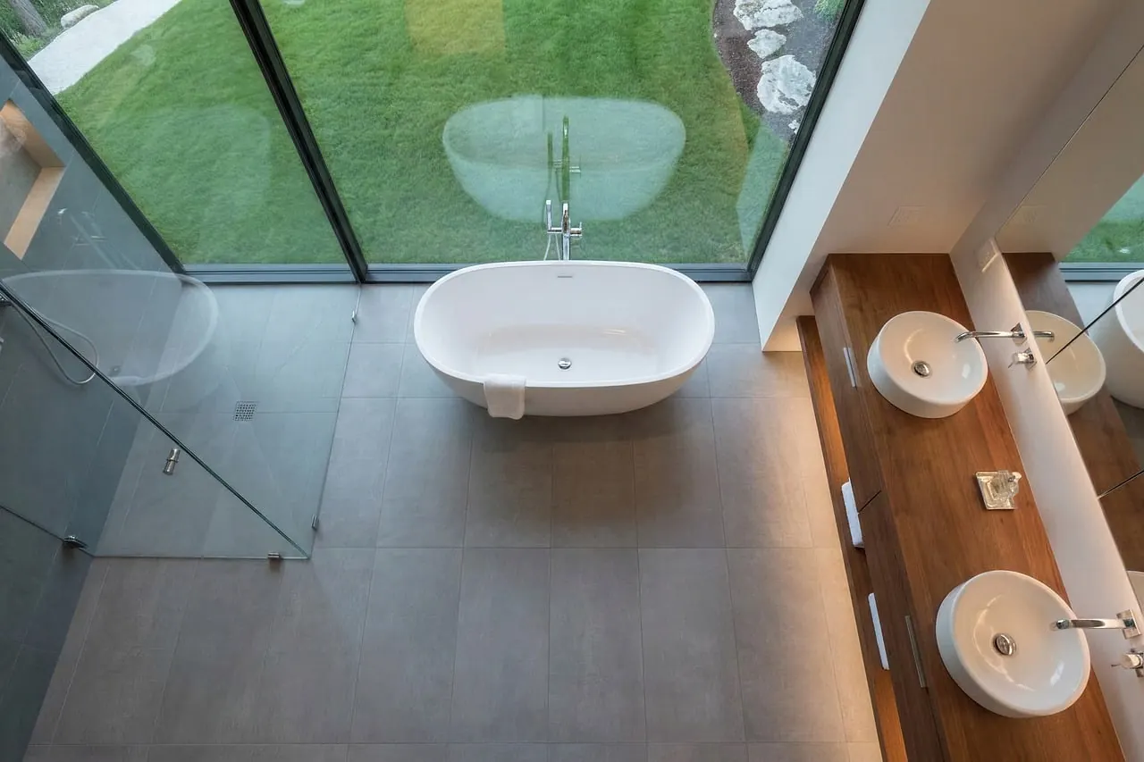 Finished modern bathroom with tiles, glass shower and double sink