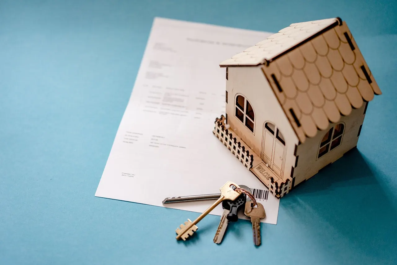 House model, keys and a sale agreement for a property purchase