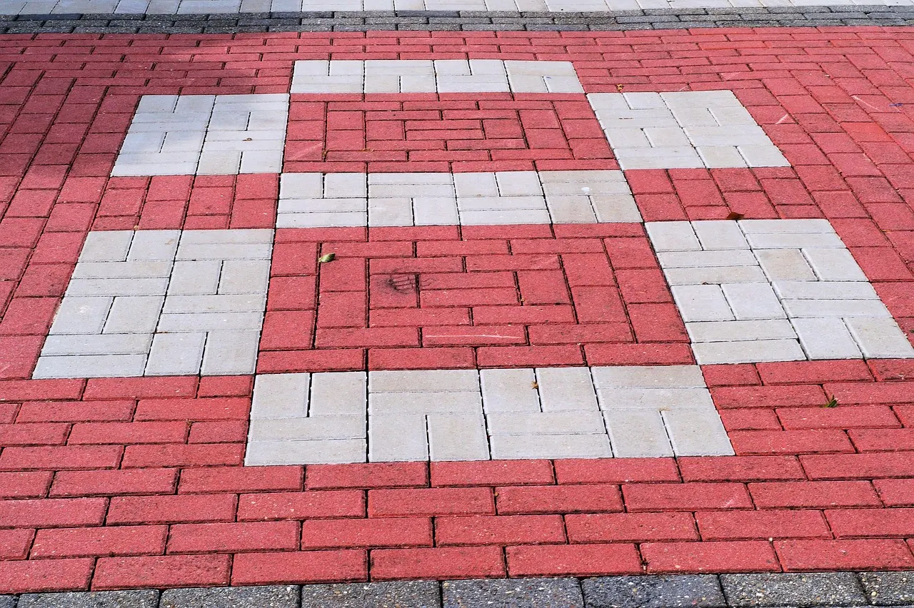 Driveway paved with red and white paving blocks in a pattern