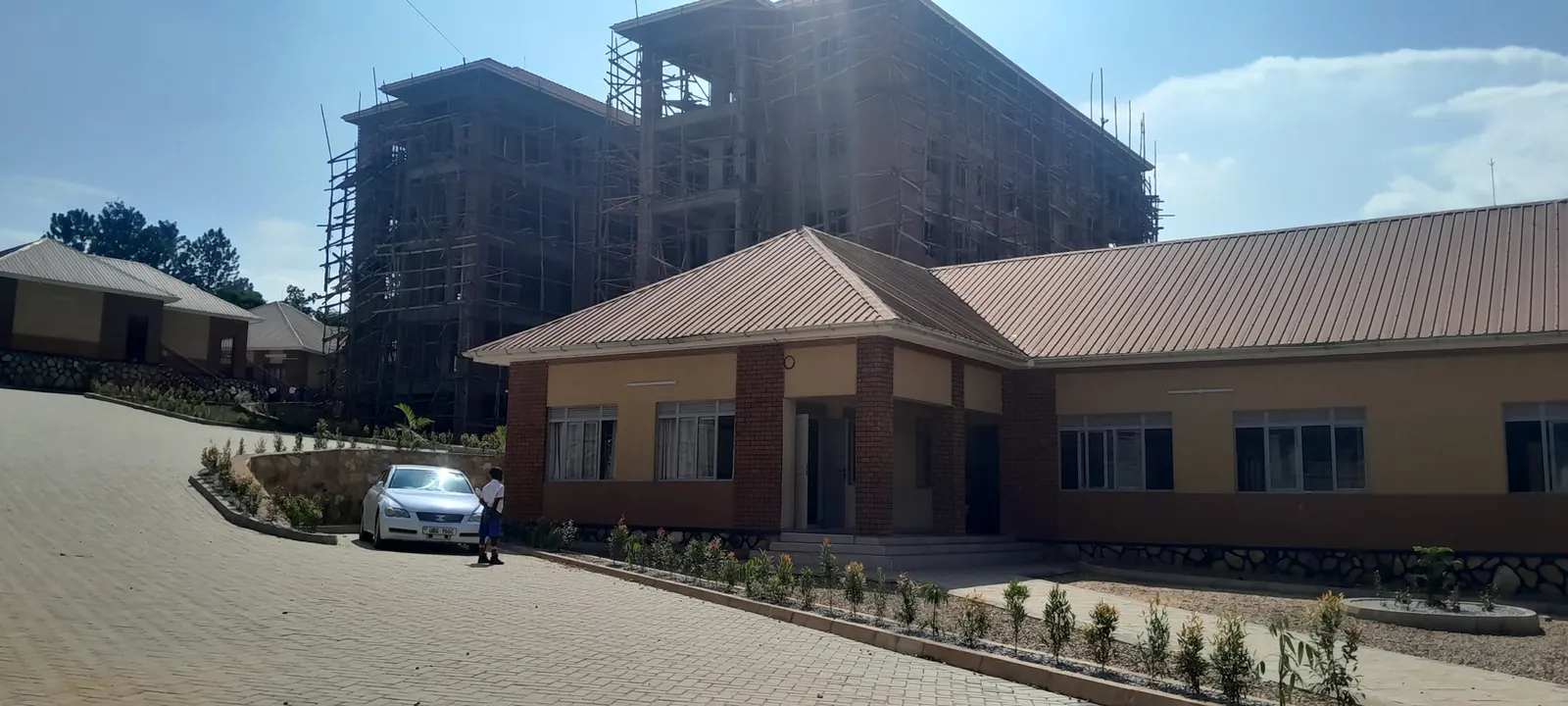 School buildings under construction with completed single-storey blocks in Uganda