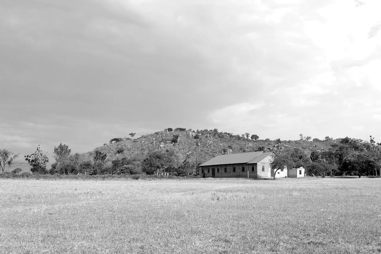 Church building on open land below a hill in Uganda
