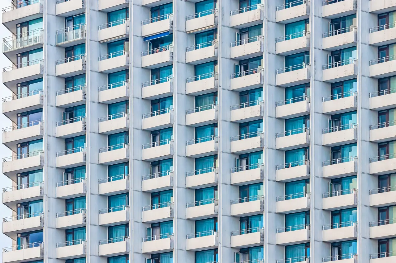 White apartment tower with rows of balconies